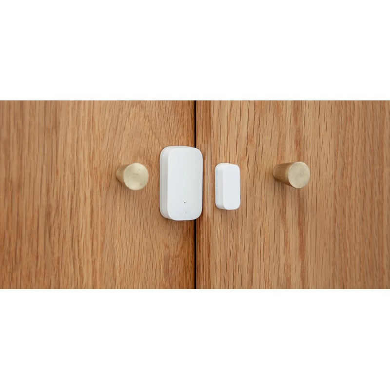 Aqara DW-S03D czujnik drzwi i okien Czujnik Aqara Door & Window Sensor T1 DW-S03D na drewnianej szafie - biały czujnik otwarcia drzwi i okien z magnesem.