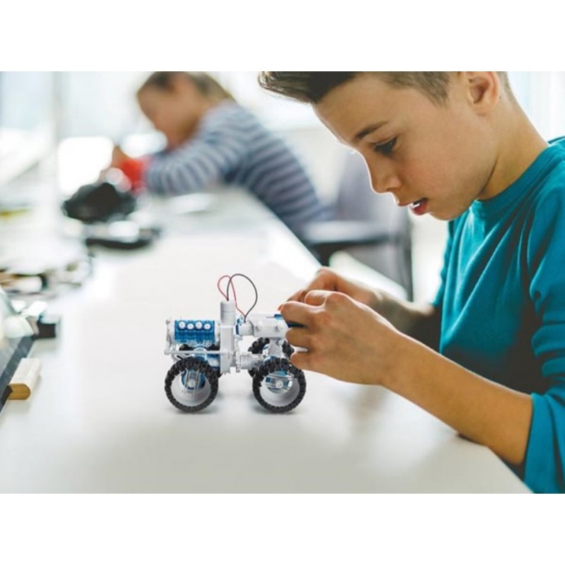 Chłopiec konstruuje model samochodu terenowego LEGO Technic zasilany słoną wodą - edukacyjny zestaw do budowy.