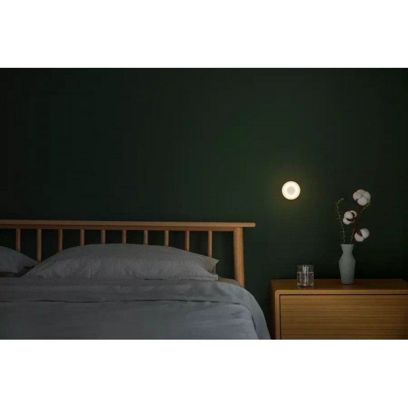 Xiaomi Mi Motion-Activated Night Light - lampka nocna Bluetooth z czujnikiem ruchu, ciepłe światło na zielonej ścianie.
