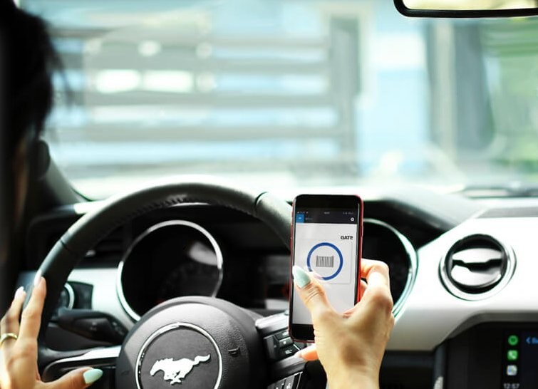 BleBox gateBox: Kobieta otwiera bramę garażową kodem QR z telefonu w samochodzie Ford Mustang. Bezkluczykowy dostęp.