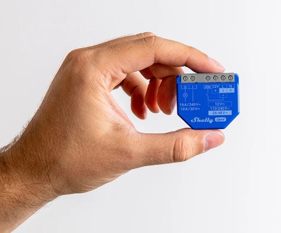 Shelly 1 Gen4 – sterownik Zigbee/Matter. Zdjęcie modułu Shelly w dłoni, schemat podłączenia i oznaczenia napięcia.