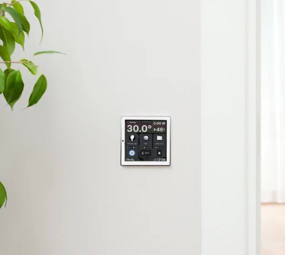 Honeywell na Shelly Wall Display Shelly Wall Display z montowanym inteligentnym termostatem Honeywell oraz zieloną rośliną w tle